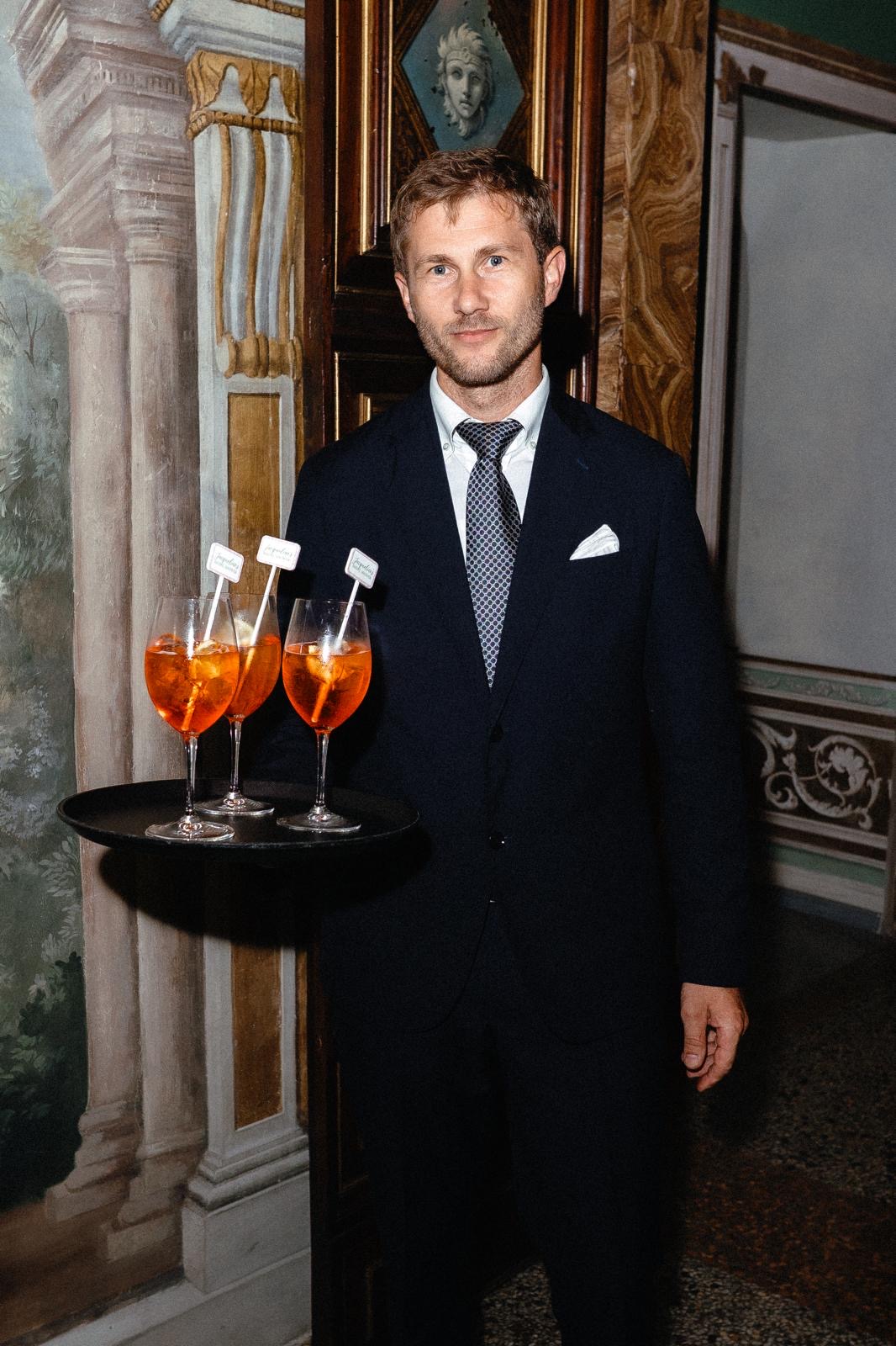Server presenting cocktails in an ornate hall