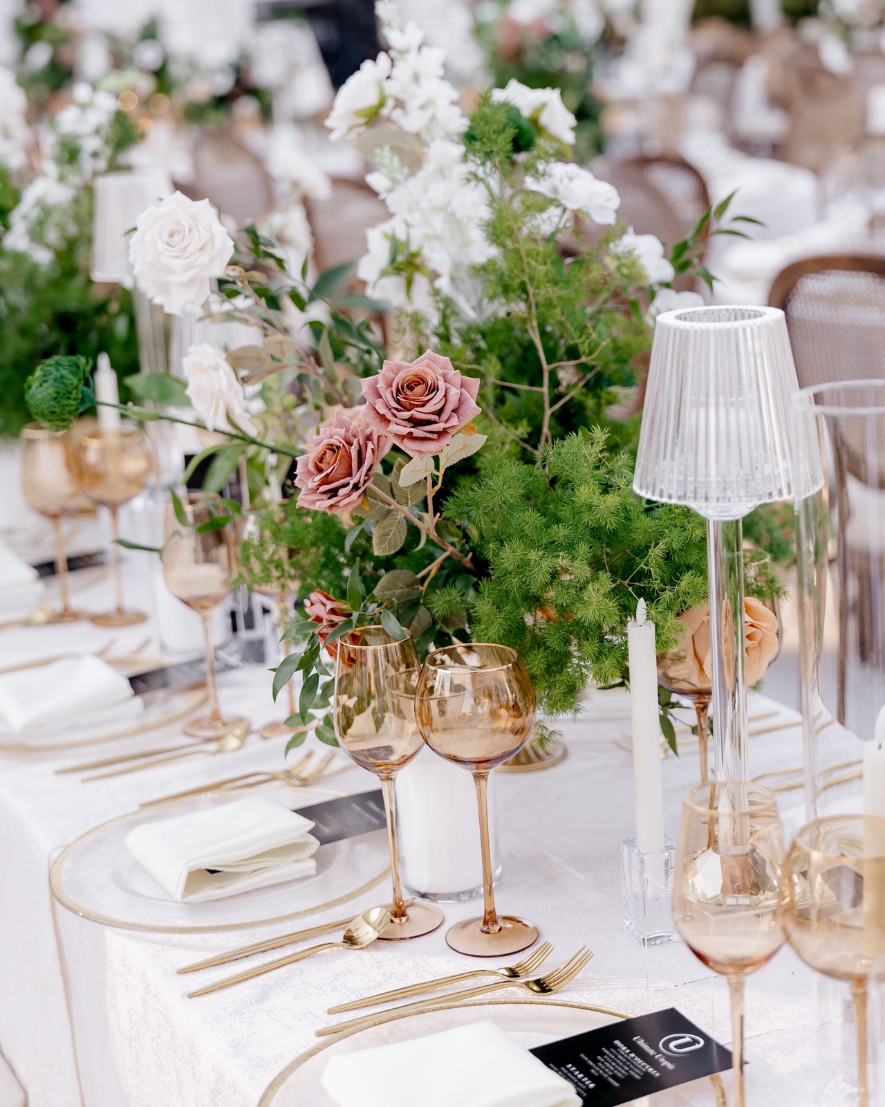 Gold-rimmed tablescape with blush florals and candlelight